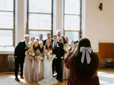 Fotografka robi wspólne zdjęcie Pary Młodej z drużbami i druhnami