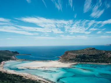 Turkusowa laguna Balos na Krecie z białą mierzeją i półwyspem pod błękitnym niebem