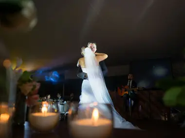 Państwo Młodzi tańczą pierwszy taniec przy świecach, w tle gitarzysta grający na żywo