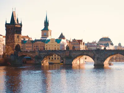 Most Karola i wieże Starego Miasta w Pradze nad Wełtawą w ciepłym świetle