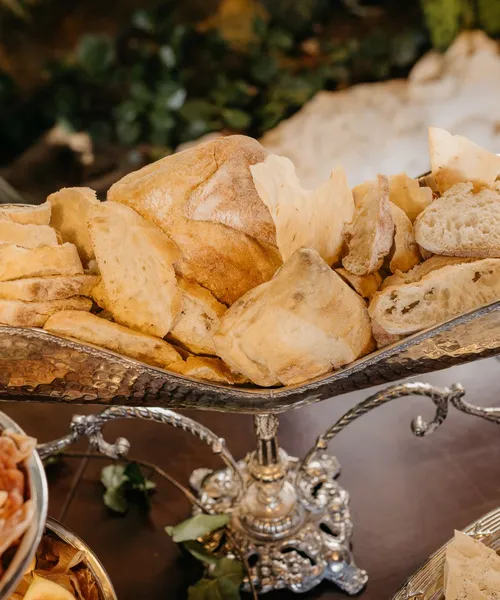 Pieczywo w srebrnej paterze na stole weselnym