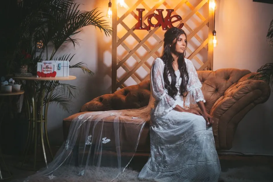 Panna młoda w koronkowej sukni w stylu boho na kanapie
