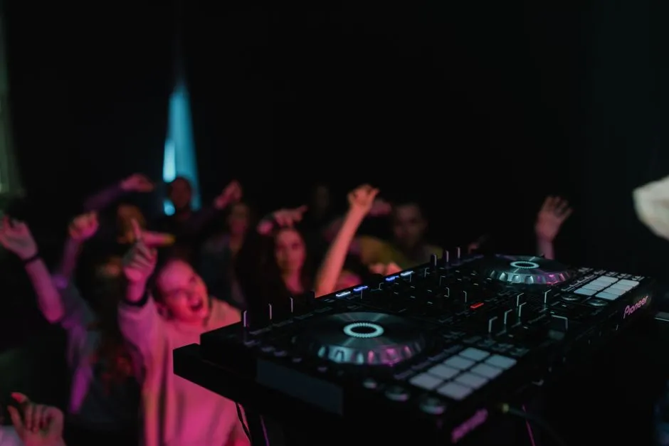Konsoleta DJ-a i tańczący goście