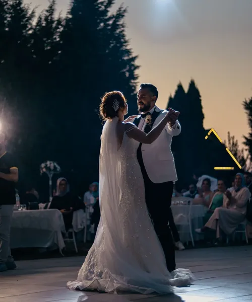 Pierwszy taniec pary młodej o zmierzchu w plenerze