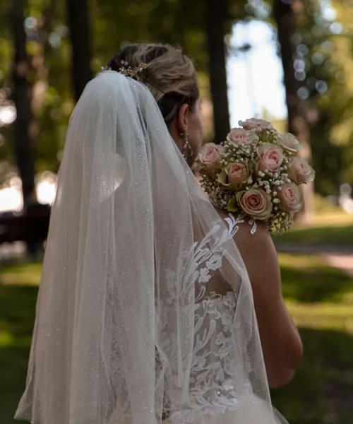 Panna młoda z bukietem w lesie, widok od tyłu