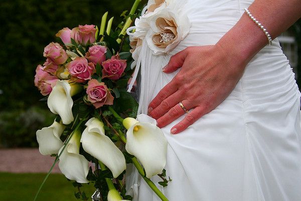 Na sukni ślubnej ładnie prezentują się drobne złote elementy: lamówka, kwiatowy czy złota koronka